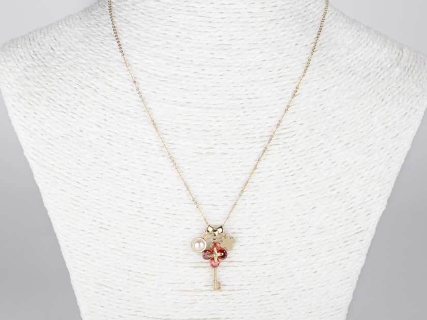 Colgante compuesto por tres colgantes: una falsa perla, una llave dorada engastada con cristales rojos y una cruz dorada