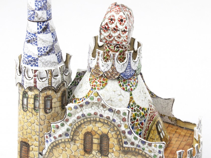 Small assembled paper model of the Park Güell pavilion in front of its packaging