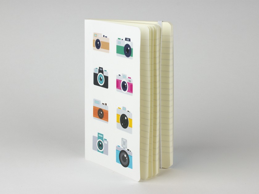 Cuaderno de pie que muestra una tapa ilustrada con varias cámaras en color.