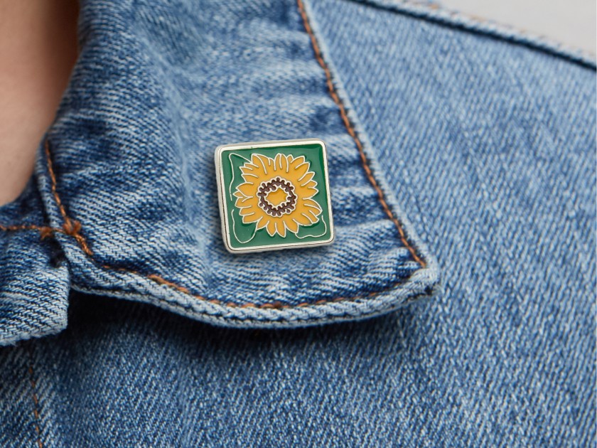 metal pin representing a sunflower seen from the front and back