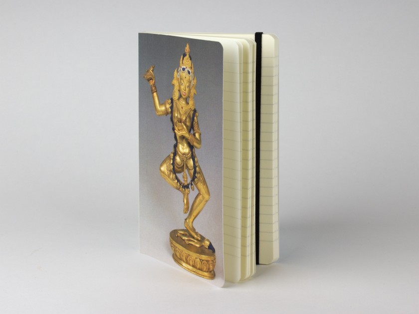 notebook with a statuette of the Buddhist goddess Vajravârâhî on the cover.