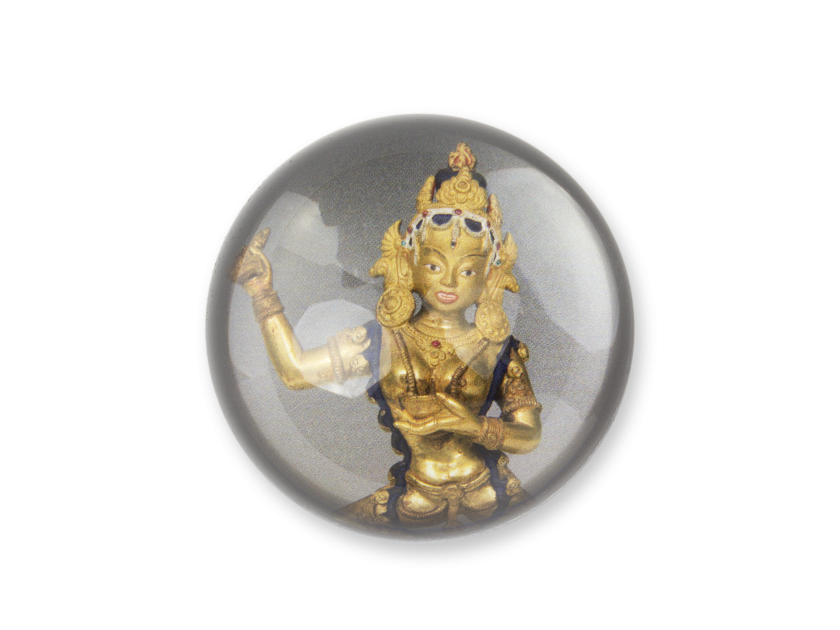 Paperweight seen from above with the image of a statuette of the Buddhist goddess Vajravârâhî.