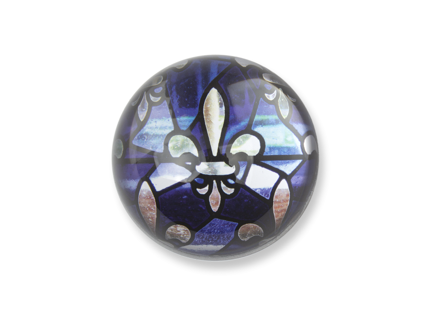 glass paperweight seen from above with a fleur-de-lys inside