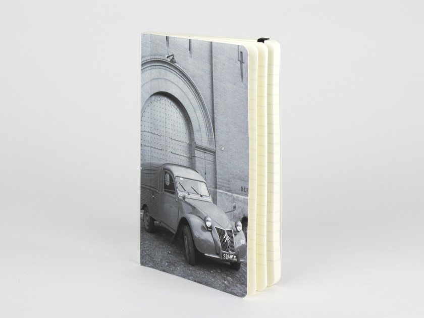notebook seen from the front with a cover illustrated with a black and white photo of a 2CV van parked in front of the Castelet