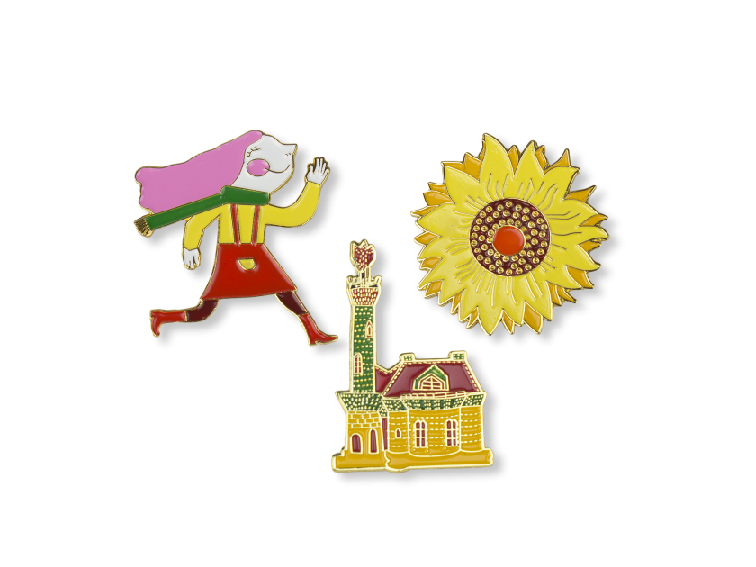 3 enamelled pins representing a girl, a sunflower and the Capricho by Gaudí