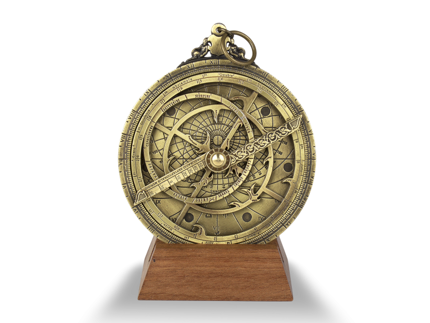Astrolabio planisférico de metal dorado sobre base de madera