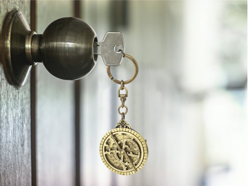llavero de metal dorado que representa un mini astrolabio