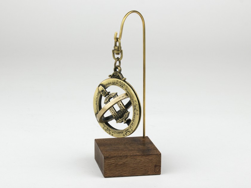 anillo astronómico de metal dorado sobre una base de madera