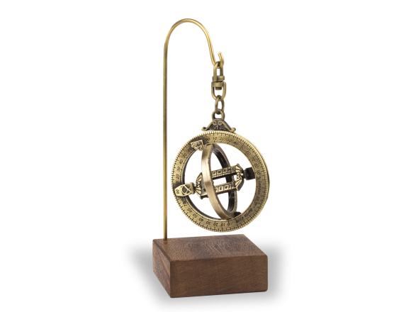 anillo astronómico de metal dorado sobre una base de madera