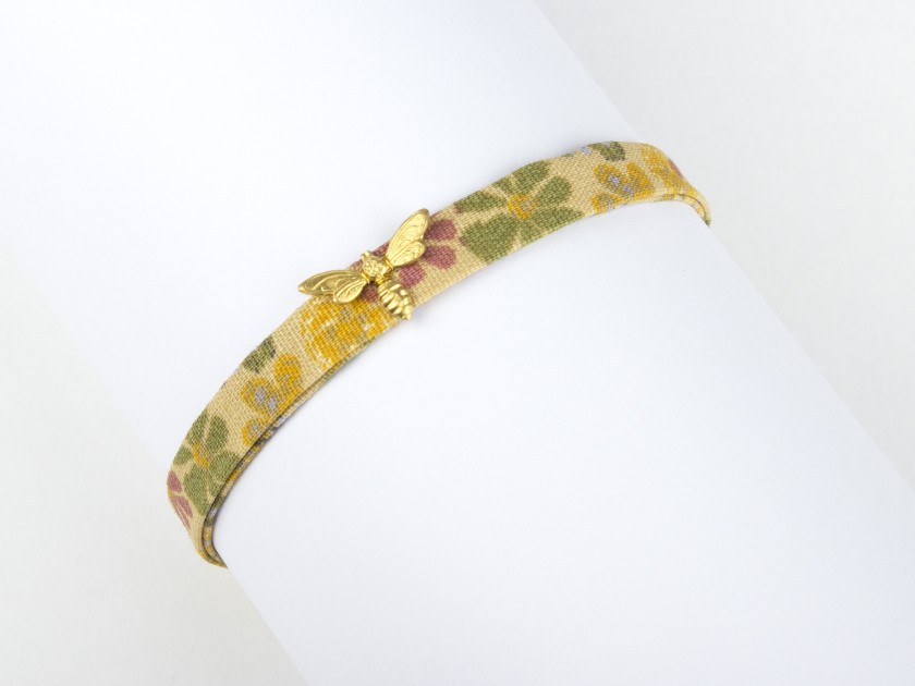 mustard coloured fabric bracelet with a golden bee sewn on