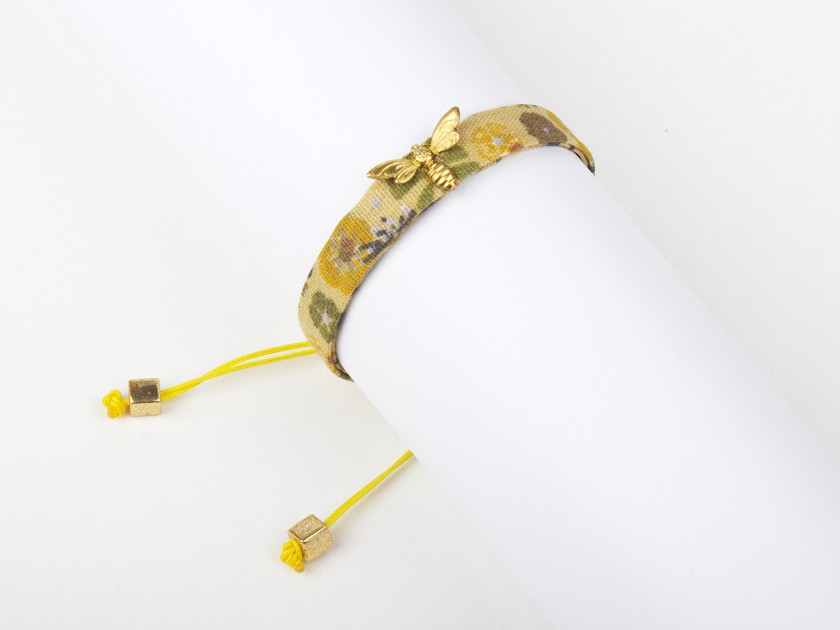 pulsera de tela floreada en tonos mostaza con una abeja dorada cosida