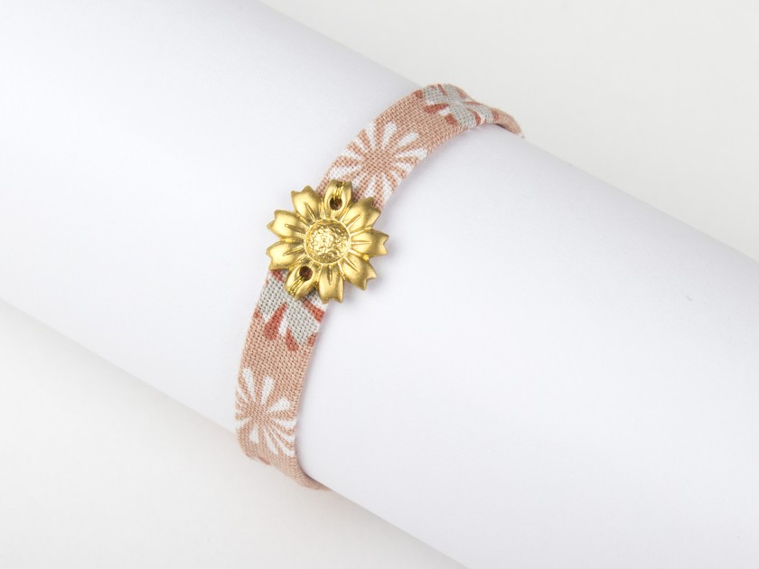 pulsera de tela rosa floreada con un girasol dorado cosido