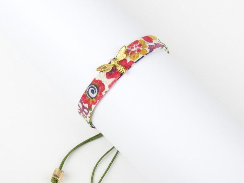 bracelet en tissu avec des motifs floraux et une abeille dorée cousue dessus