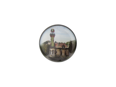 round magnet with a photo of El Capricho de Gaudí by day
