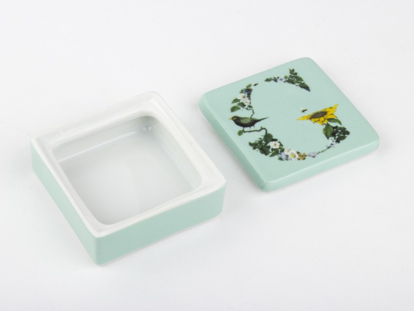 petite boîte en céramique de couleur menthe à l'eau avec une illustration de l'initiale G imprimée sur le couvercle